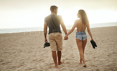 Buy stock photo Back, holding hands and couple at beach for love, care and connection together with slippers. Walking, man and woman at ocean for vacation, holiday or travel on romantic date with sunset view outdoor