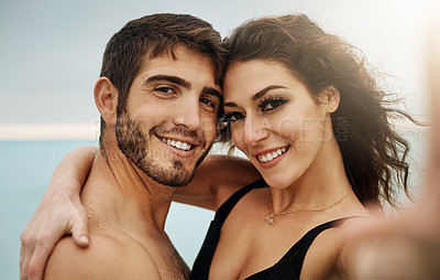 Buy stock photo Cropped shot of a young couple taking a selfie at the beach