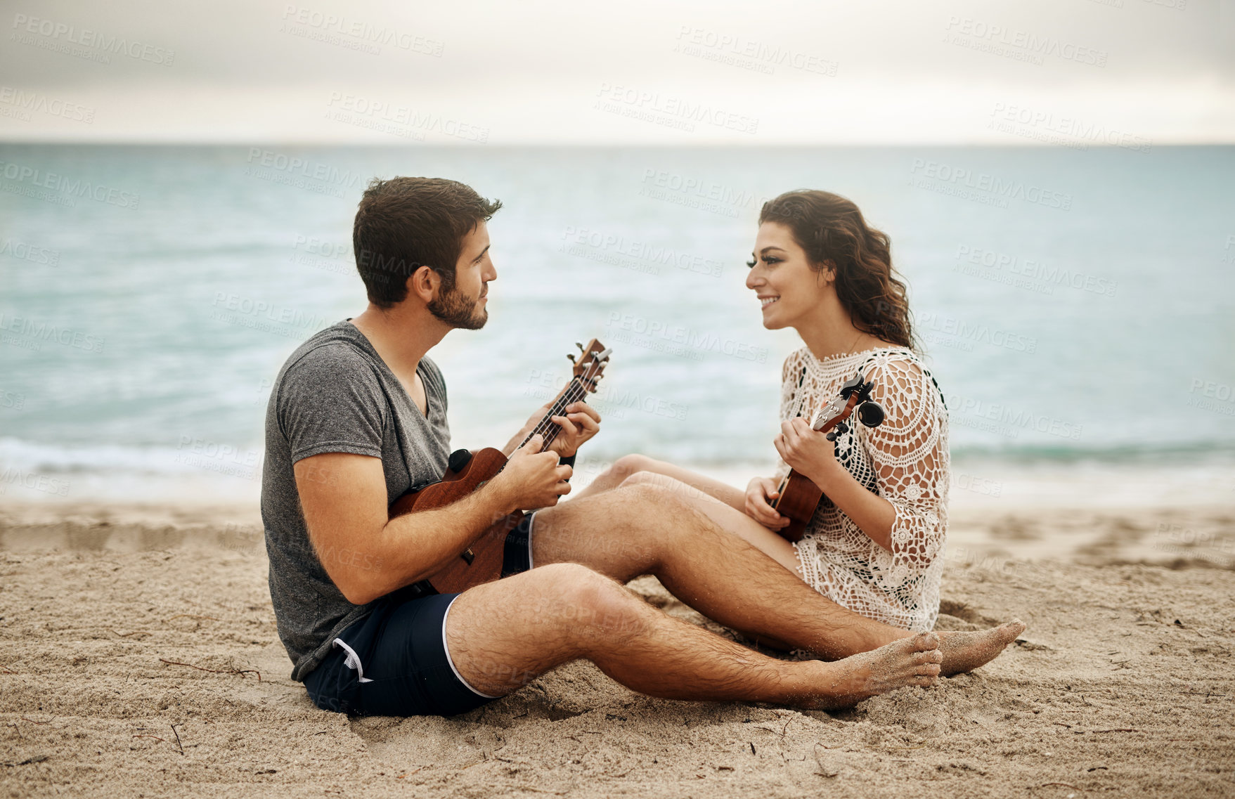 Buy stock photo Beach, couple and happy with guitar for love with music, romance and bonding as lovers. Outdoor, people and smile in relationship on date as musicians, artists and creative in ocean for care or trust