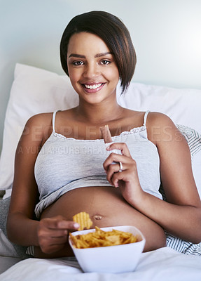 Buy stock photo Cropped shot of a pregnant woman enjoying a chocolate and potato chips in bed