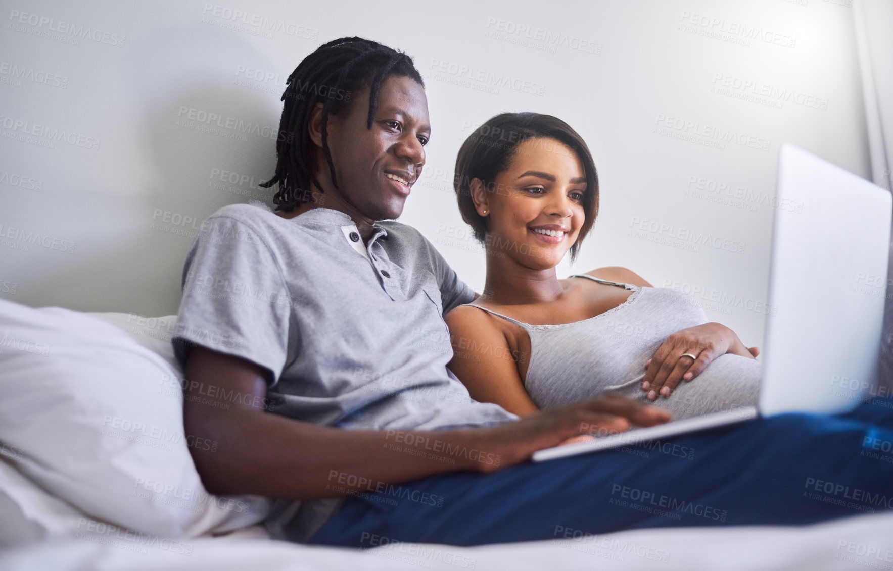Buy stock photo Shot of an expecting couple browsing the internet at home