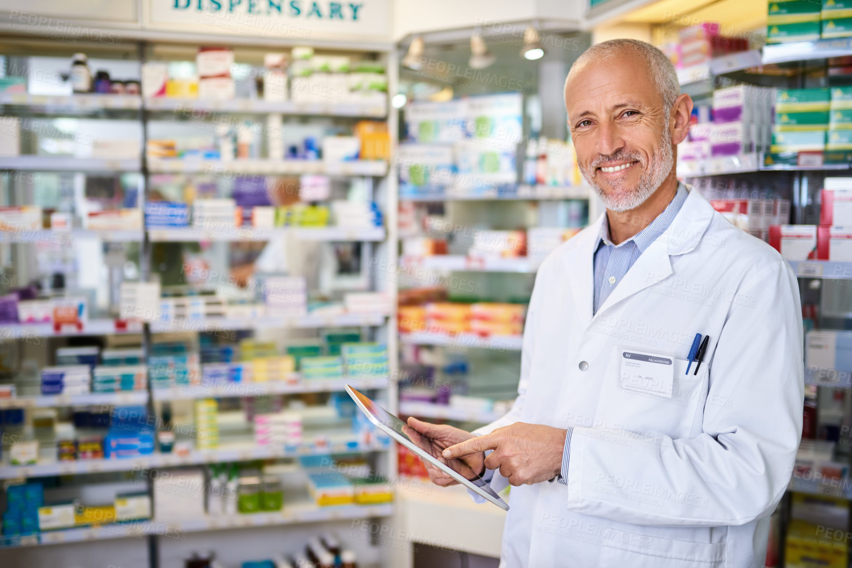 Buy stock photo Portrait of a mature pharmacist using a digital tablet while working in a chemist
