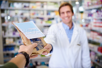 Buy stock photo Personal perspective shot of a pharmacist handing over medication to a customer in a chemist