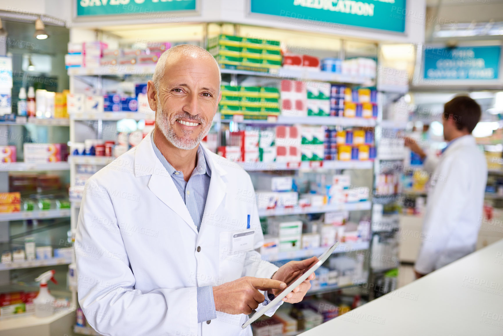 Buy stock photo Portrait of a mature pharmacist using a digital tablet while in a chemist