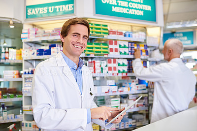 Buy stock photo Portrait of a young pharmacist using a digital tablet while in a chemist