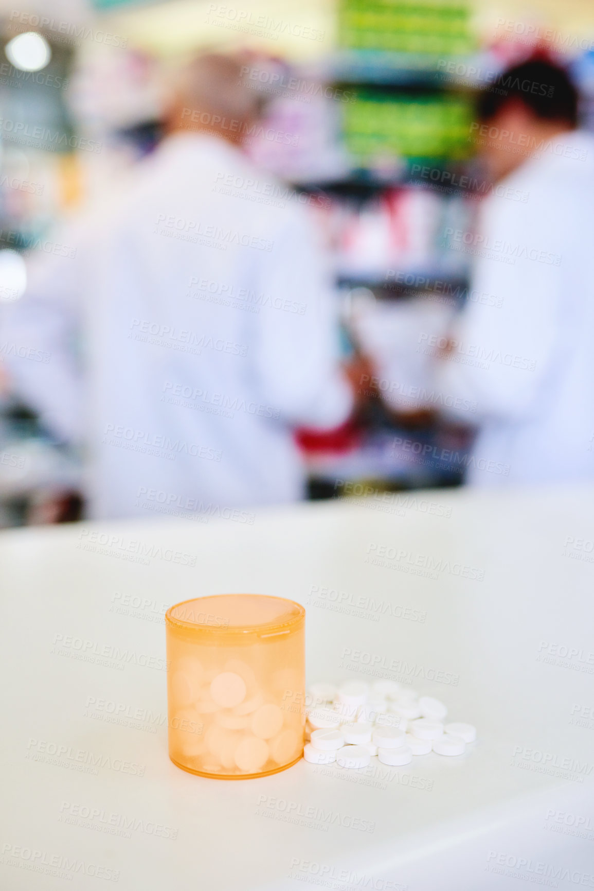 Buy stock photo Shot of a container filed with medication on a counter in a pharmacy