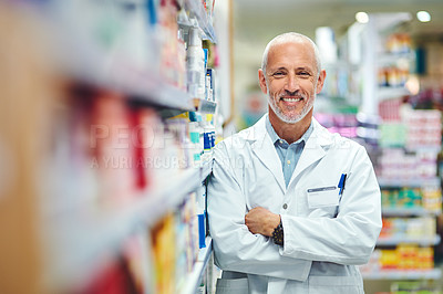 Buy stock photo Cropped portrait of a handsome mature male pharmacist standing with his arms crossed in the pharmacy