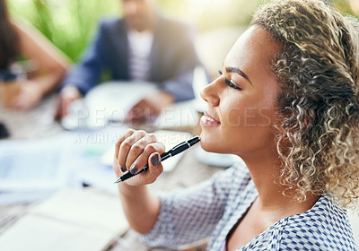 Buy stock photo Shot of a young businesswoman looking thoughtful while having a meeting with her colleagues outdoors