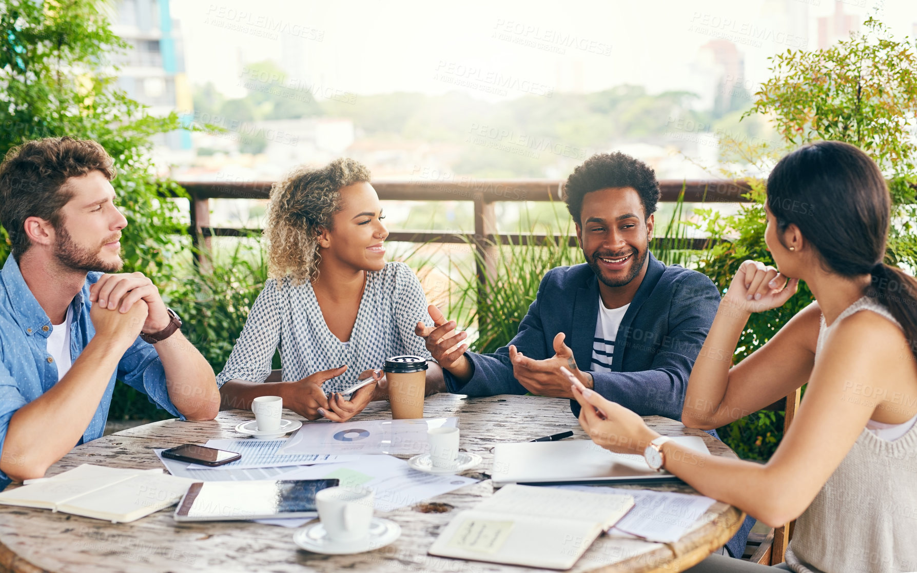 Buy stock photo Shot of a group of businesspeople having a meeting outdoors