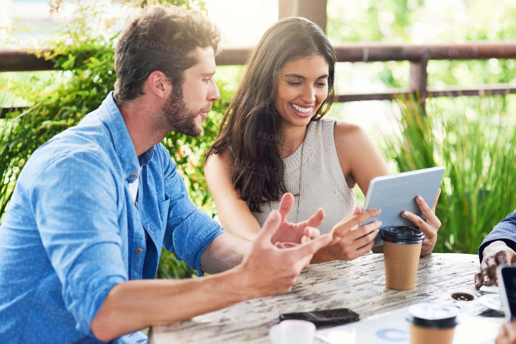 Buy stock photo Shot of two businesspeople using a digital tablet together outdoors