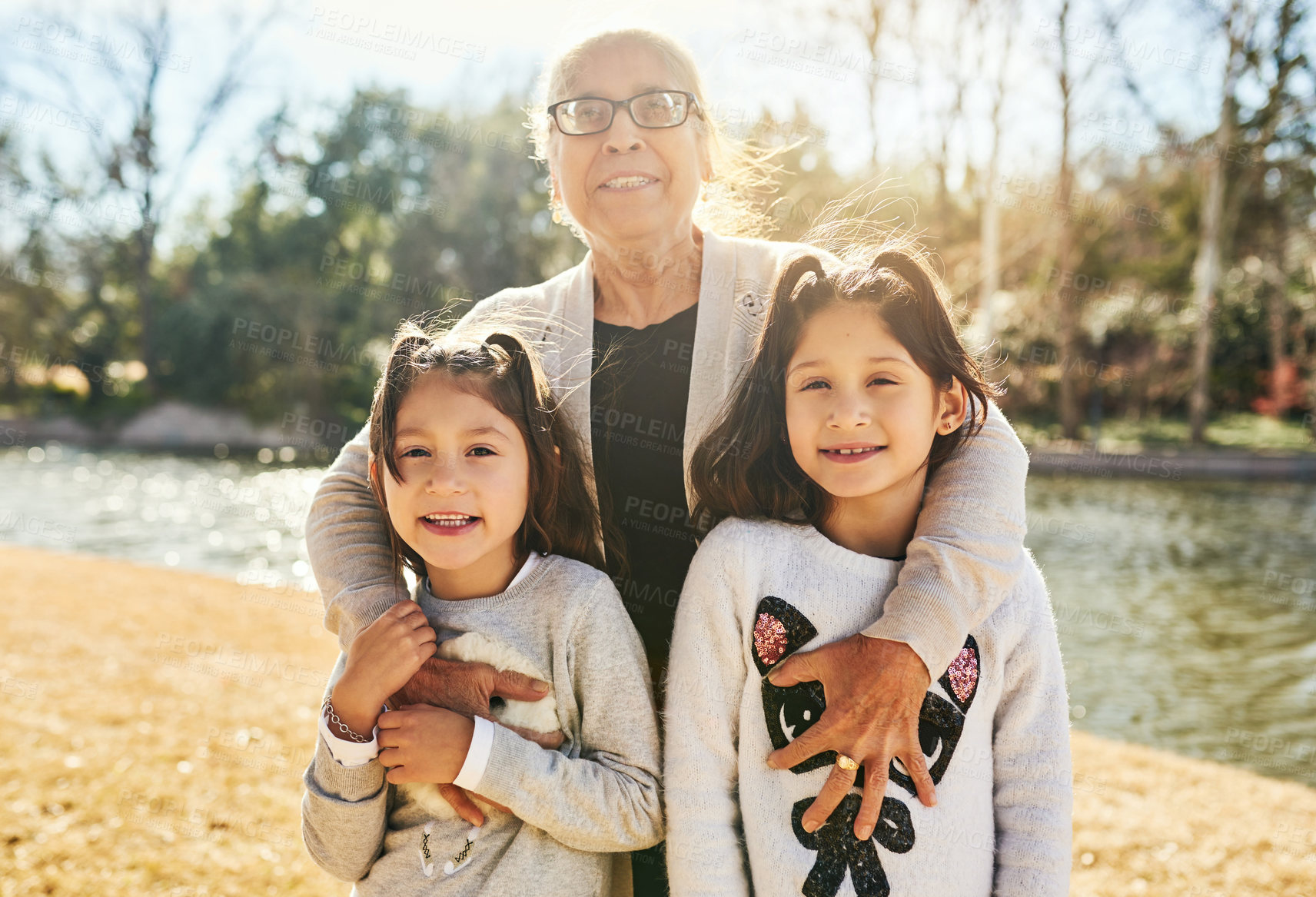 Buy stock photo Grandmother, park and hug portrait with child, girl and sister with love and smile. Care, bonding together and nature for family, happy and kid with elderly grandparent for summer vacation or holiday