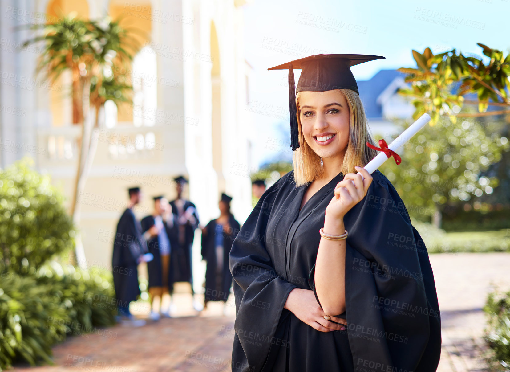 Buy stock photo Cropped shot of a happy young woman holding her certificate on graduation day