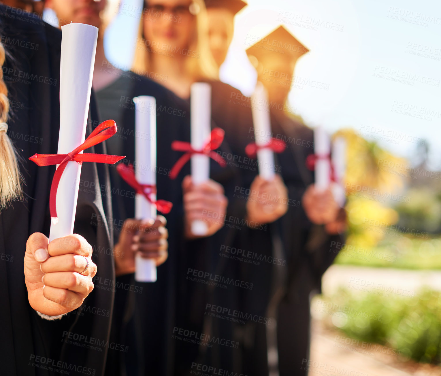 Buy stock photo Closeup shot of a group of unrecognizable students holding their diplomas on graduation day