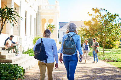 Buy stock photo Rearview shot of unrecognizable university students walking to class on campus
