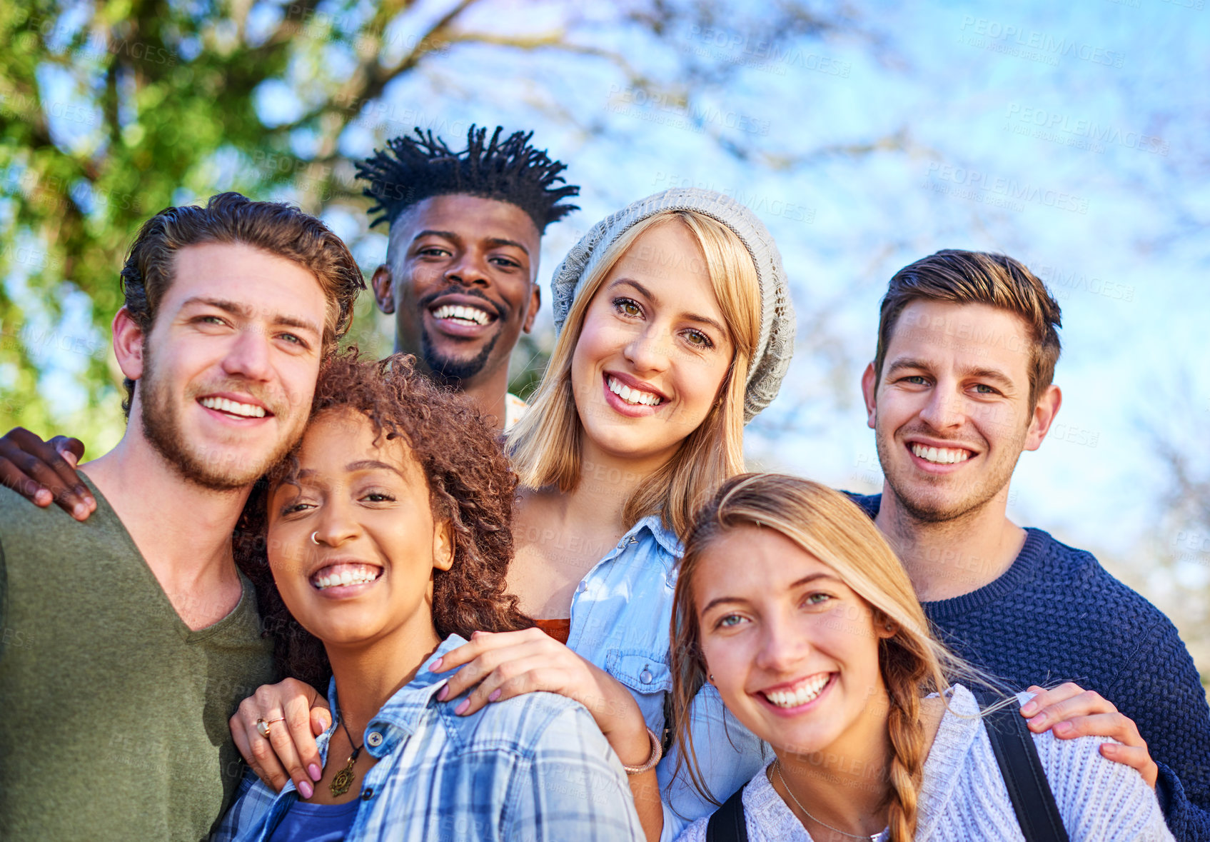 Buy stock photo Diversity, portrait and smile with group of friends outdoor on blue sky together for love or support. Face, happy or love with men and women in nature park for bonding, community or wellness