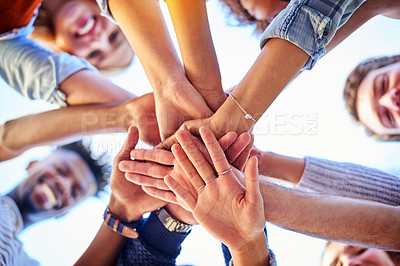 Buy stock photo Low angle shot of university students standing outside with their hands together