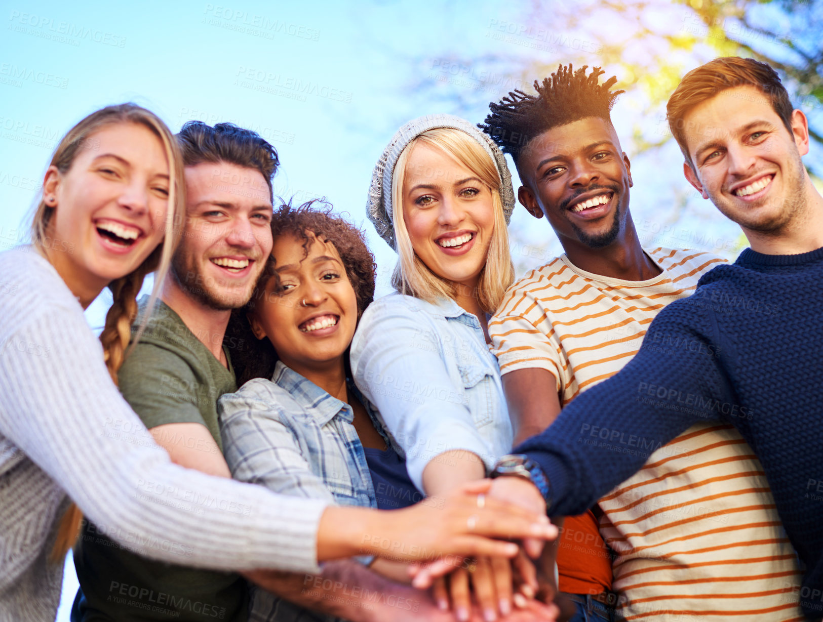 Buy stock photo Cropped shot of a group of diverse students huddled together with their hands piled on top of each other