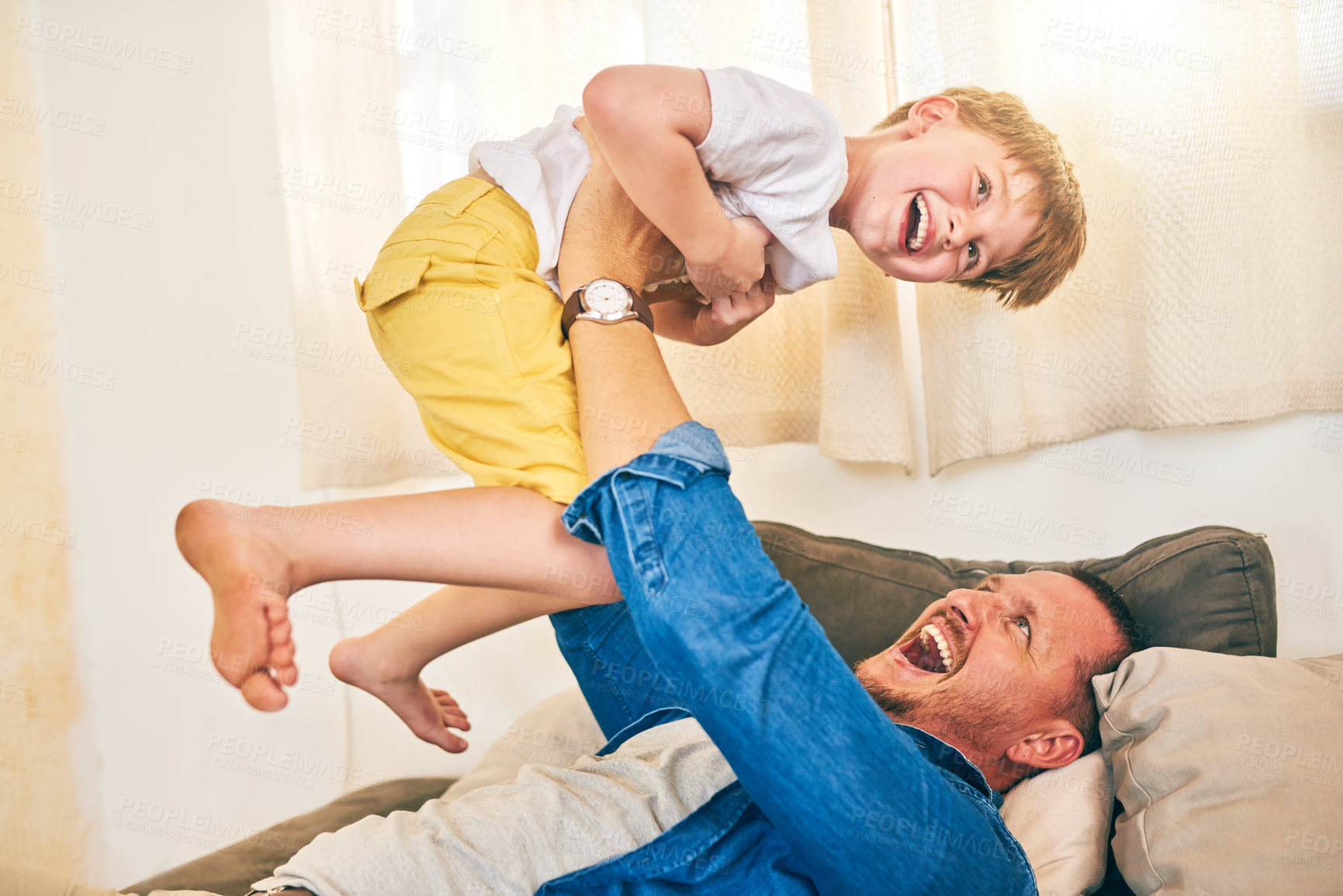 Buy stock photo Shot of a happy little boy having fun with his father at home