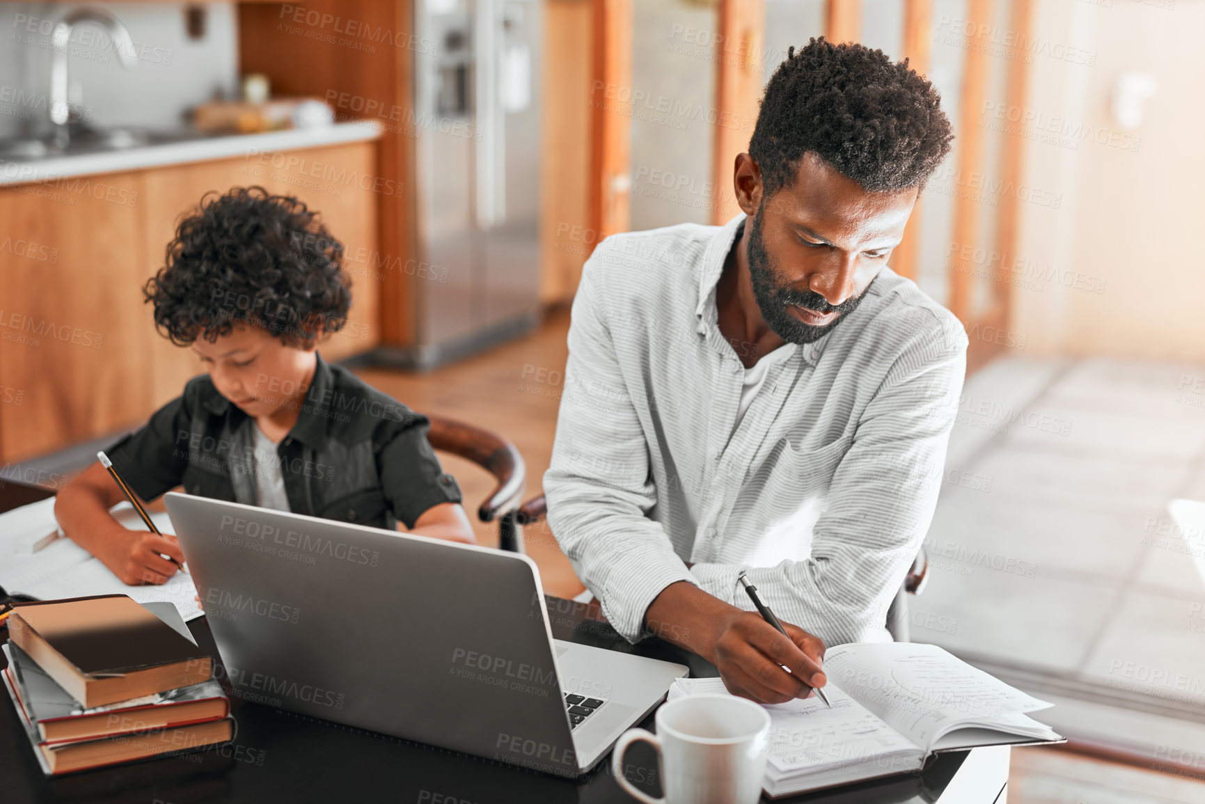 Buy stock photo Shot of a man using his laptop while sitting with his son