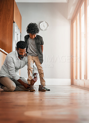 Buy stock photo Shot of a man tying his little boy's shoelaces