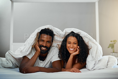 Buy stock photo Cropped shot of a young attractive couple in bed at home