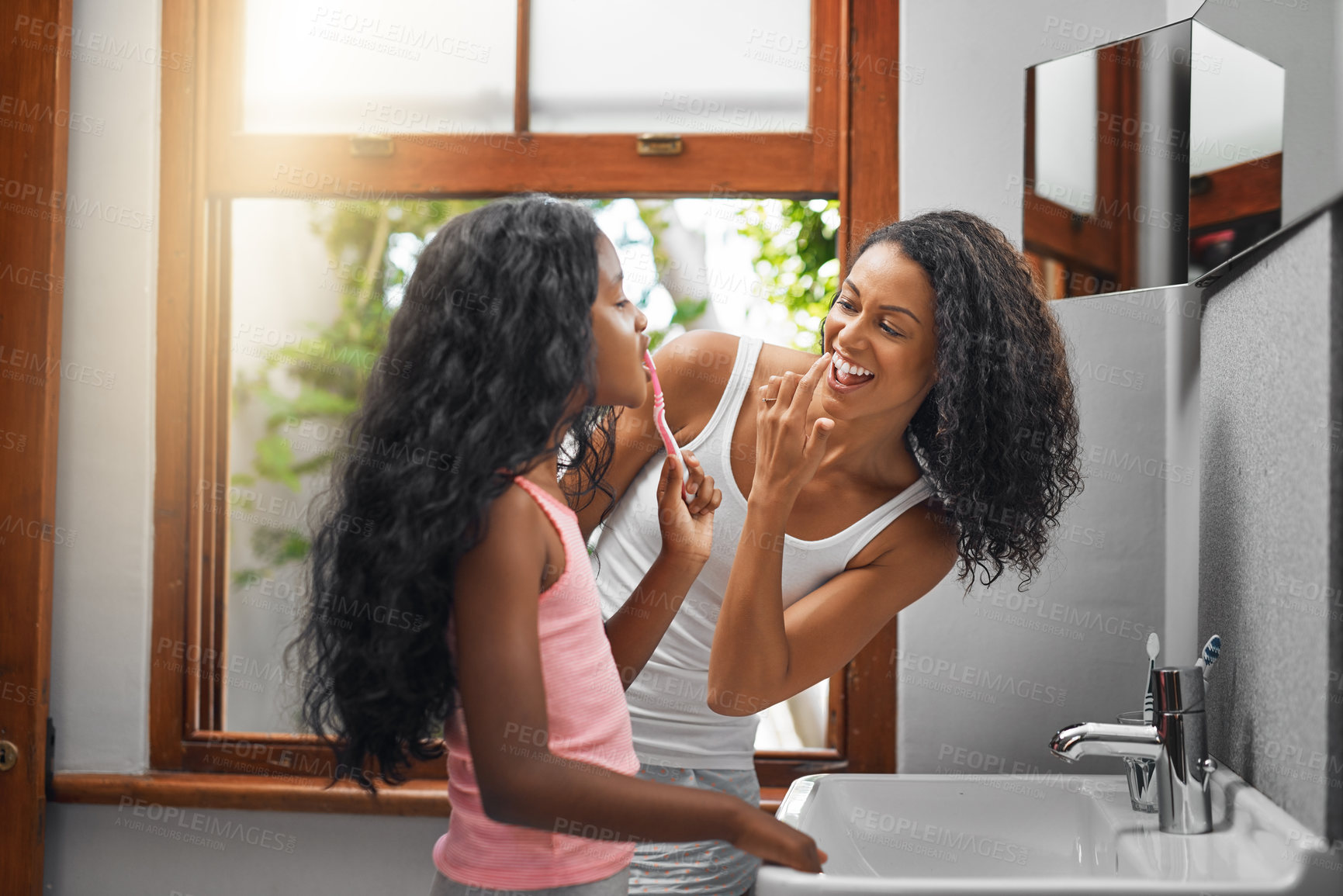 Buy stock photo Cropped shot of an attractive young woman and her daughter brushing their teeth in the bathroom at home