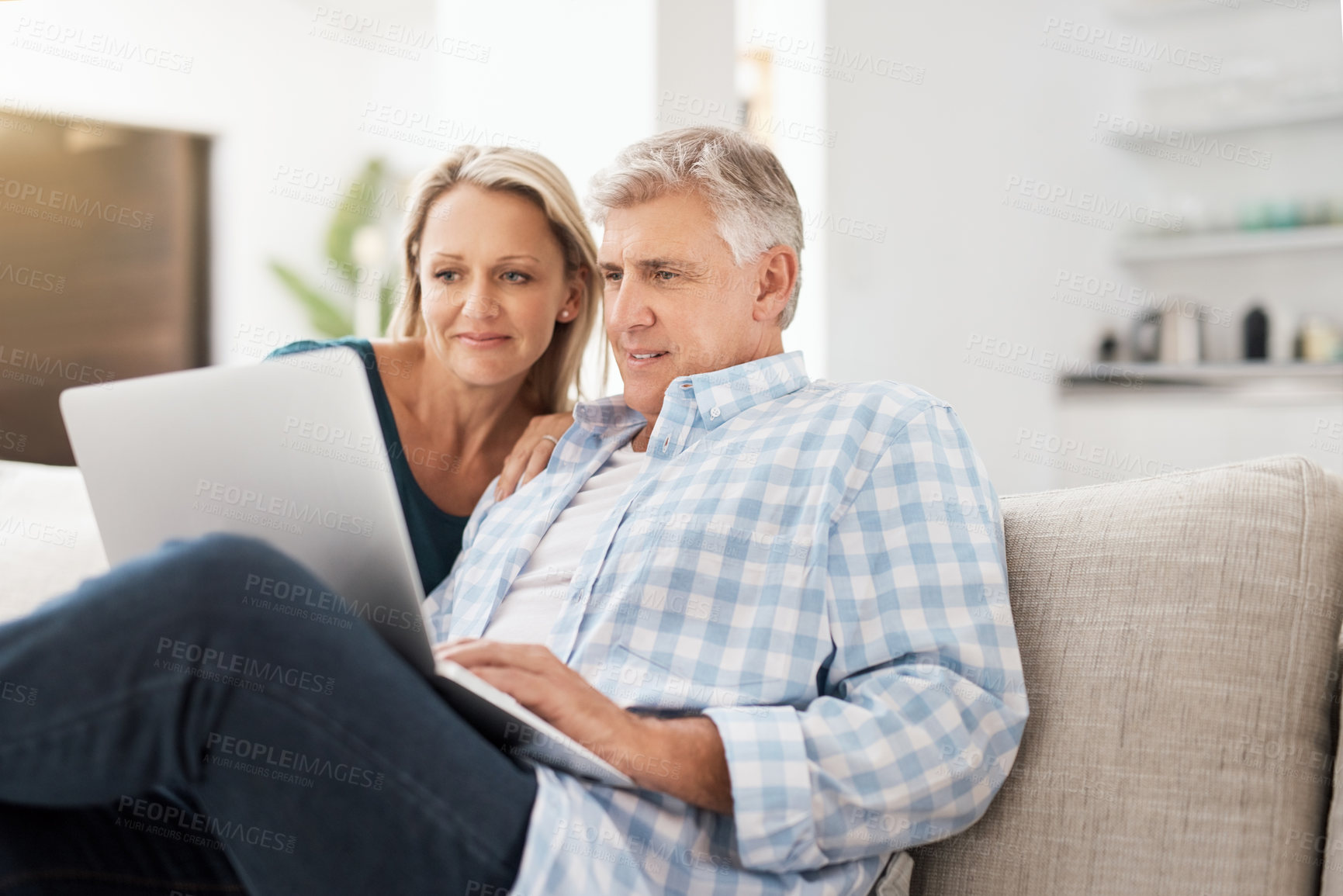 Buy stock photo Couple, couch and laptop in home and read, news and email in living room for social media. Internet, computer and relax for website or streaming with married people, calm and lounge with technology