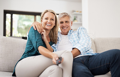 Buy stock photo Cropped portrait of an affectionate mature couple watching television together at home