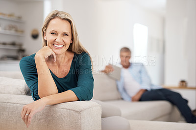 Buy stock photo Portrait of an attractive mature woman relaxing at home with her husband in the background