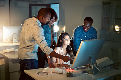 Buy stock photo Shot of a group of colleagues working late together on a computer in an office