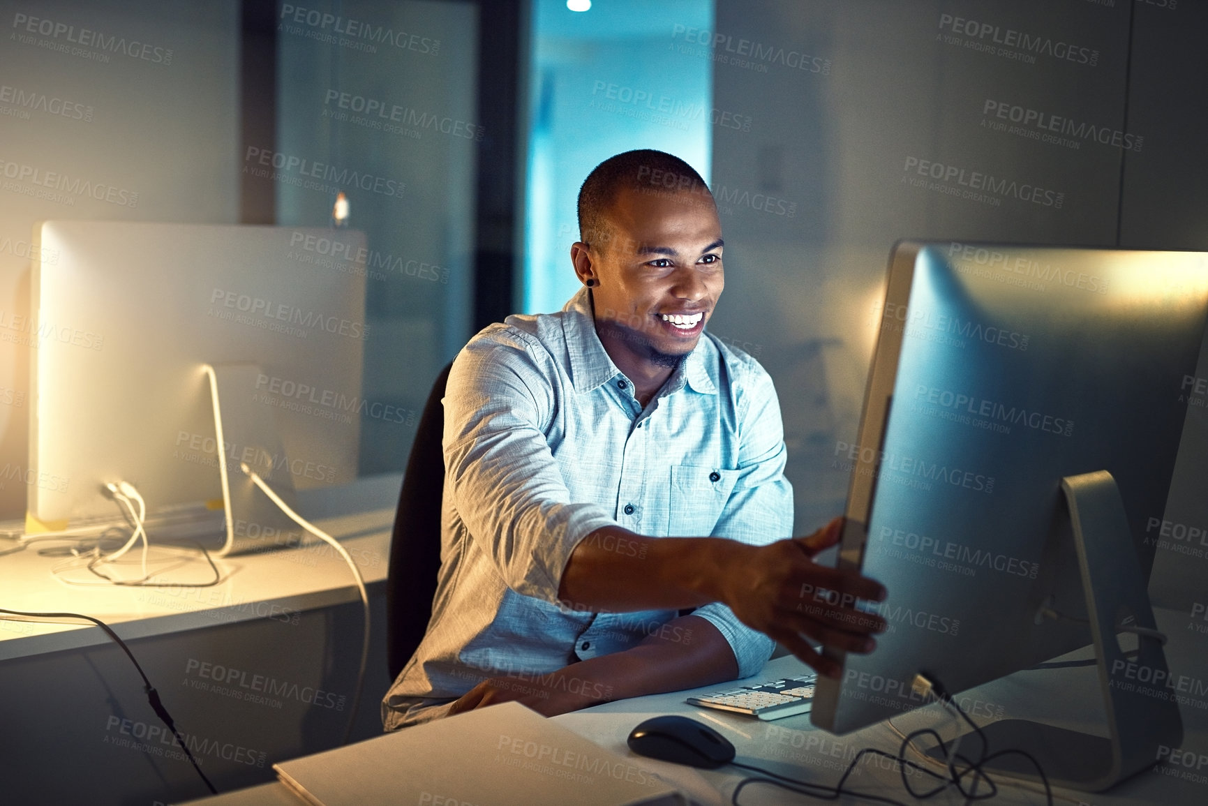 Buy stock photo Shot of a young businessman working late in an office