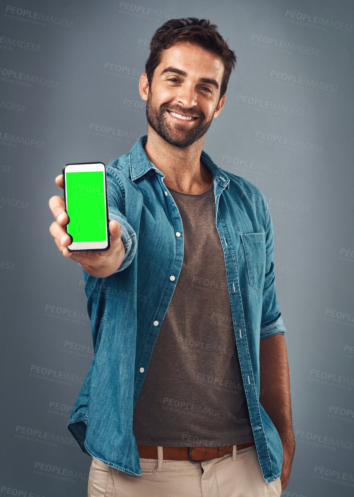 Buy stock photo Happy man, phone and mockup green screen for advertising or marketing against a grey studio background. Portrait of male person smiling and showing smartphone display or chromakey for advertisement