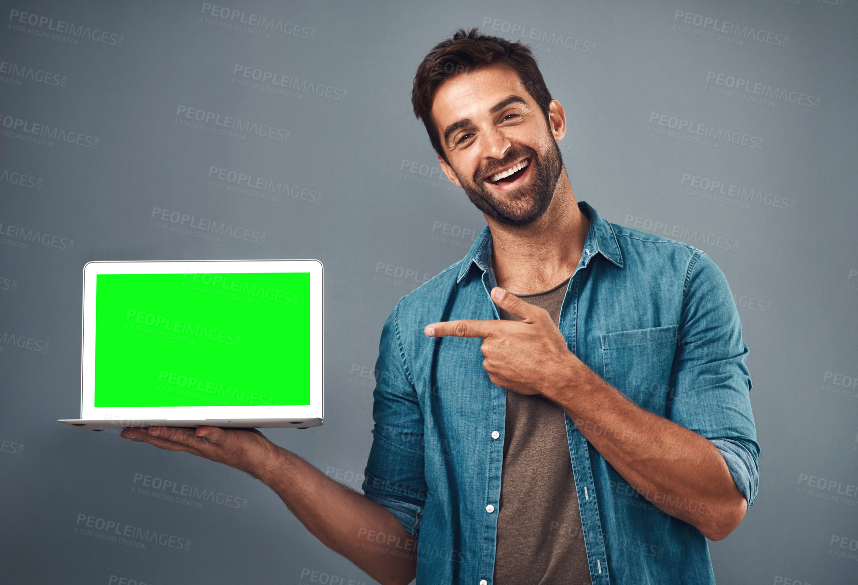 Buy stock photo Happy man, tablet and pointing to green screen for advertising against a grey studio background. Portrait of male person smiling and showing technology display, chromakey or mockup for advertisement
