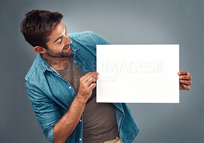 Buy stock photo Man, billboard sign and mockup for marketing, advertising or branding against a grey studio background. Male person holding rectangle shape poster or placard for advertisement message with copy space