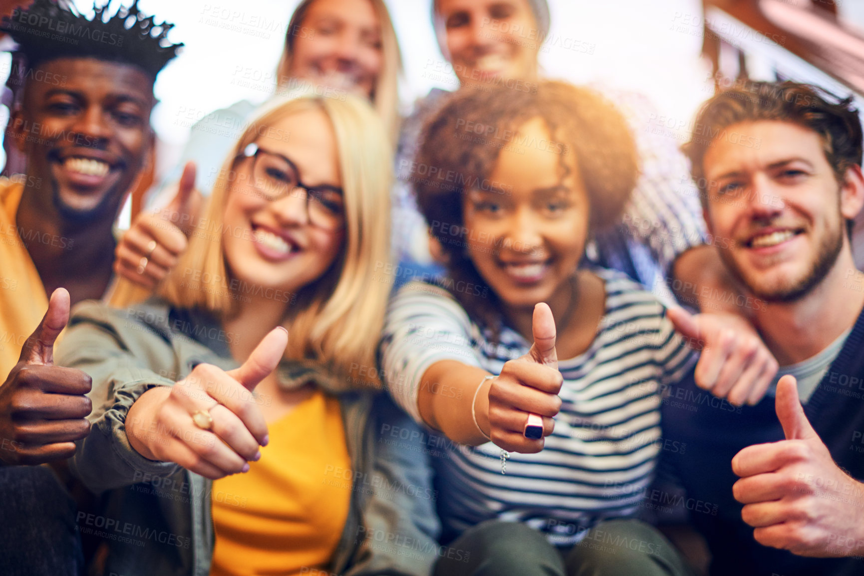 Buy stock photo Portrait of a group of diverse university students showing a thumbs up while sitting on the staircase on campus