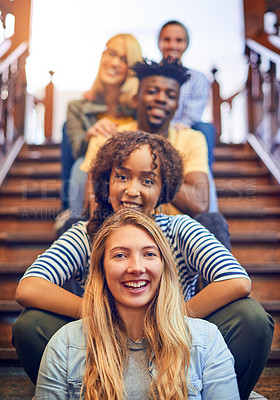 Buy stock photo Portrait of a group of diverse university students sitting in a row on the staircase on campus