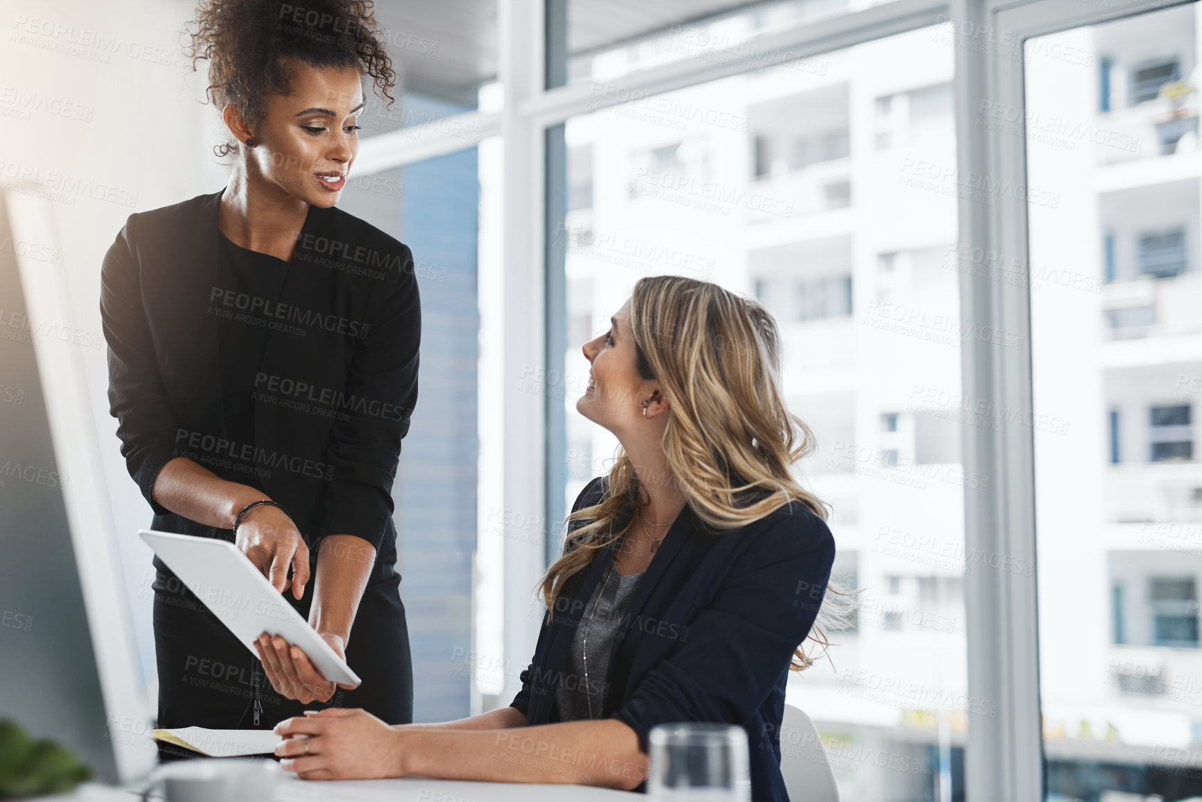 Buy stock photo Shot of two businesswomen working together in an office