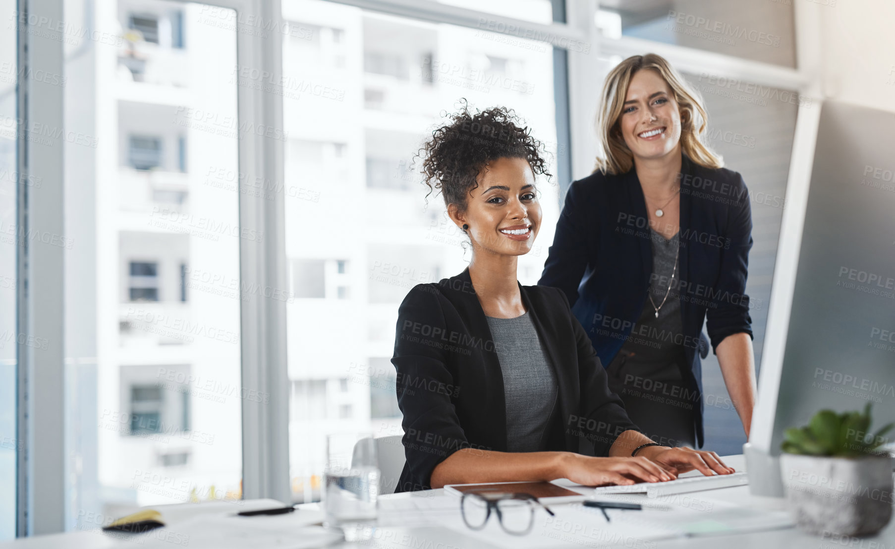 Buy stock photo Portrait of two businesswomen working together in an office