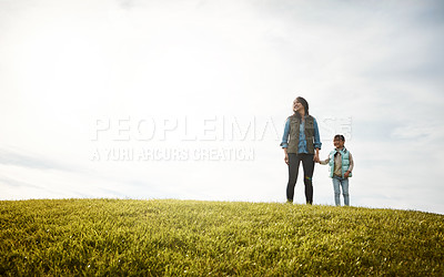 Buy stock photo Shot of a woman holding her little girl's hand as they walk outdoors