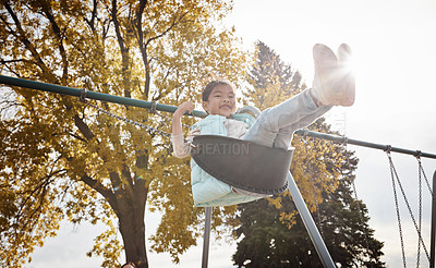 Buy stock photo Portrait of an adorable little girl playing on a swing at the park