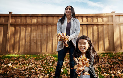 Buy stock photo Autumn, throw leaves and mother with daughter in garden of home together for bonding or love. Asian family, fall or playing with single parent woman and girl child having fun in backyard for wellness