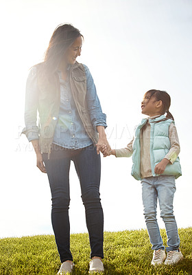 Buy stock photo Daughter, field and walk with mother holding hands, fun and woman in park for outdoor outing. Love, bonding and support from mom person and girl, grass and family in autumn for countryside together