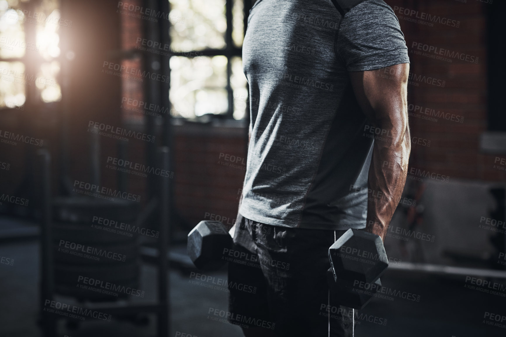 Buy stock photo Cropped shot of an unrecognizable man working out with dumbbells