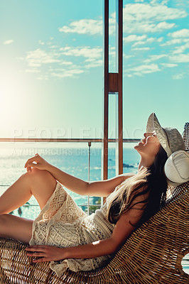Buy stock photo Shot of an attractive young woman relaxing outside on her balcony in the sun