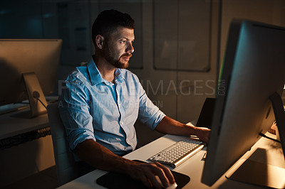 Buy stock photo Shot of a mature businessman working late on a computer in an office