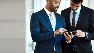 Buy stock photo Cropped shot of unrecognizable businessmen using a cellphone together outside