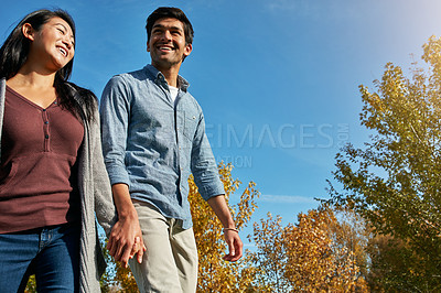 Buy stock photo Shot of a loving young couple out for a walk in the park