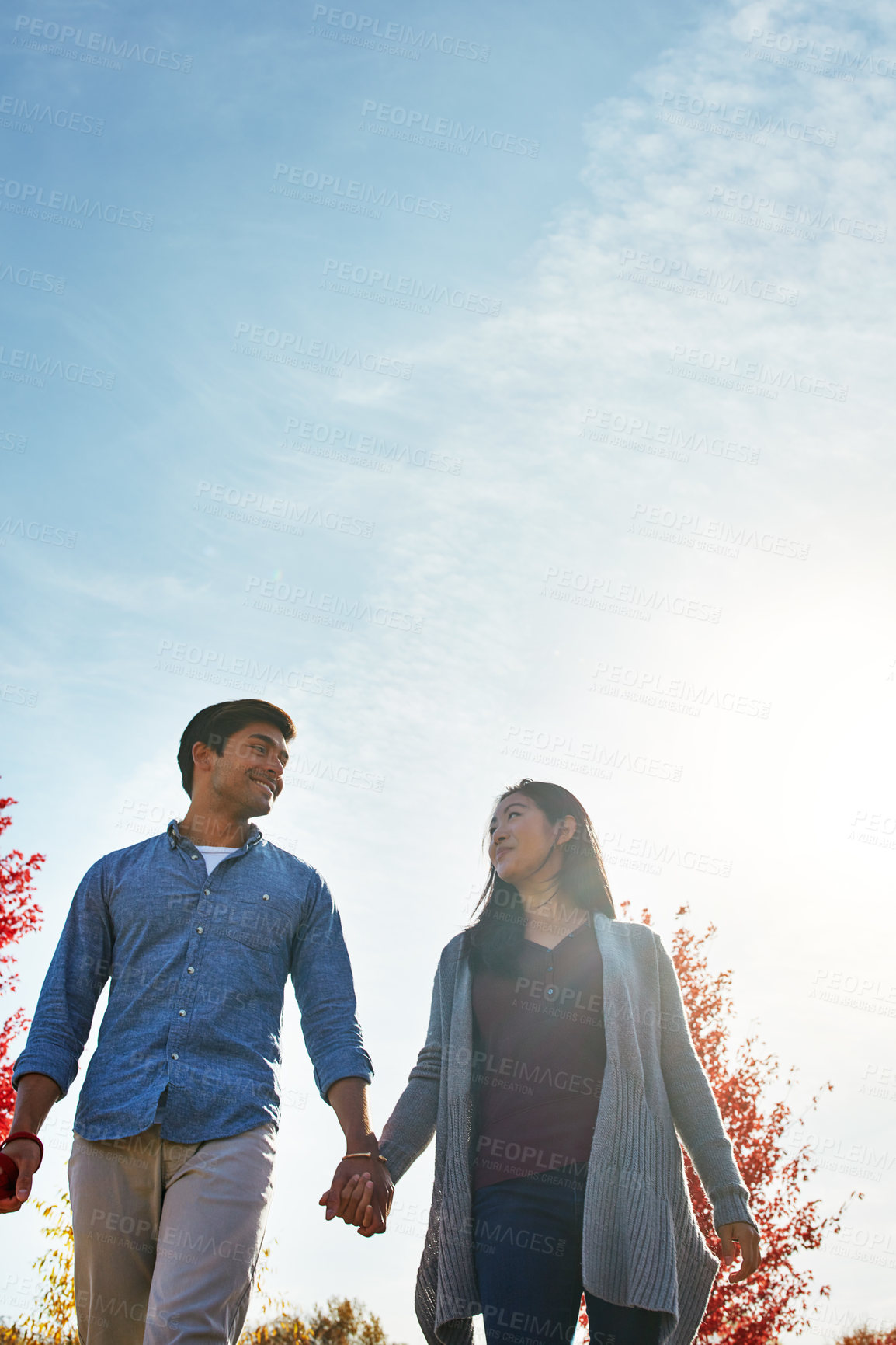 Buy stock photo Shot of a loving young couple out for a walk in the park