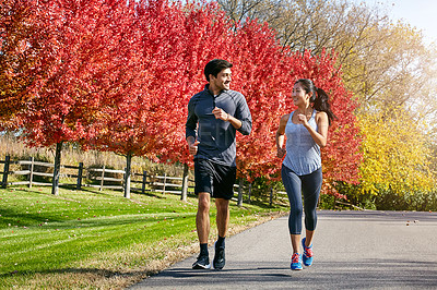 Buy stock photo Shot of a sporty young couple exercising together outdoors