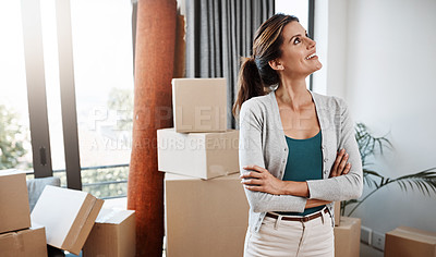 Buy stock photo Cropped shot of an attractive young woman standing with her arms folded while moving into a new house